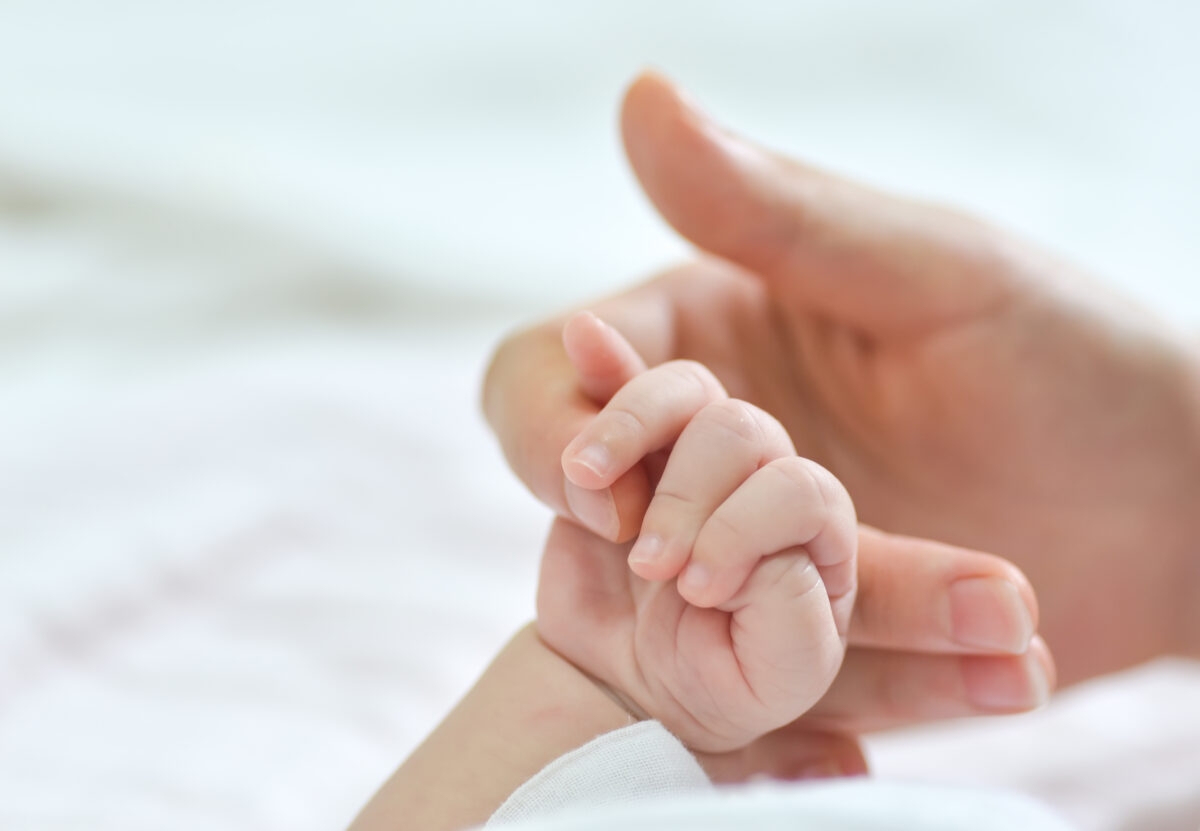 Baby and mother holding hands